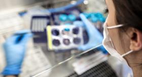 A person wearing a mask in a lab.