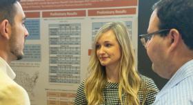 A woman in front of a research poster.