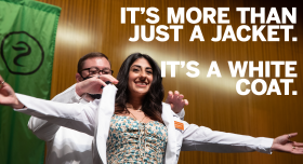 Student pharmacist being coated at the 2021 White Coat Ceremony. Text overlap reads "It's more than just a jacket. It's a White Coat."