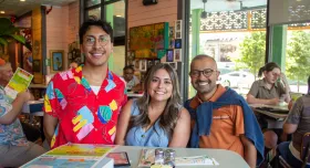 College of Pharmacy staff members smile to camera at a social gathering.
