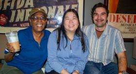 Three staff members smiling in the lobby of a movie theater.