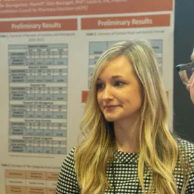 A woman in front of a research poster.