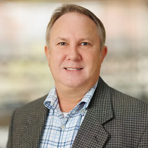 Troy Holbritter smiling and wearing checkered blazer