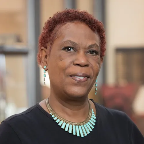 Cene Abroms wearing earrings and a necklace.
