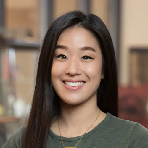 Iris Bae wearing a necklace and smiling.