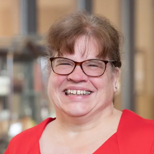 Sherrie Bendele wearing glasses and smiling.
