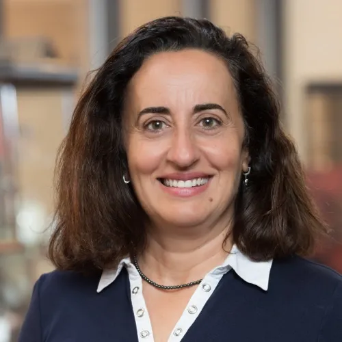 Mirna Benhamou wearing a necklace and collared top.