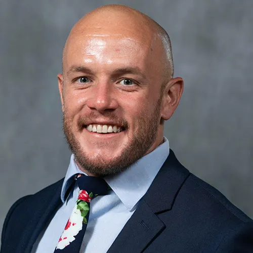 Dr. Kirk Evoy smiling and wearing a suit