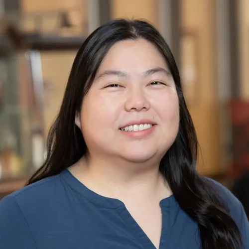 Gloria Fang smiling while wearing a solid shirt.