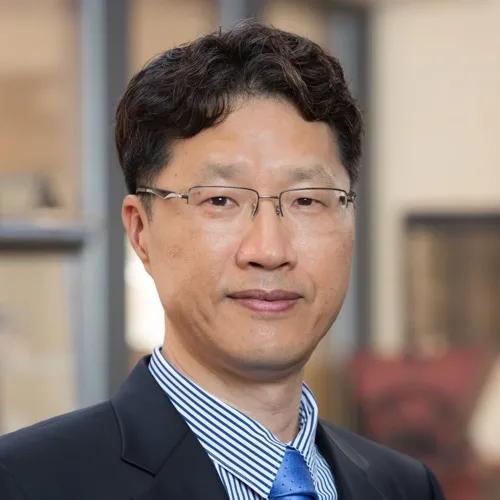 Dr. Seongmin Lee wearing a suit, tie and glasses.