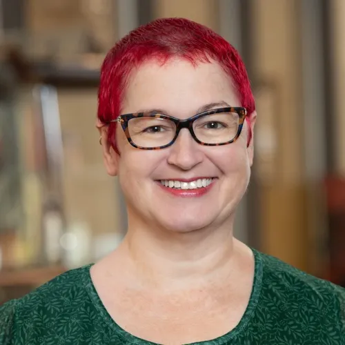 Steph Scott wearing tortoiseshell glasses and smiling.
