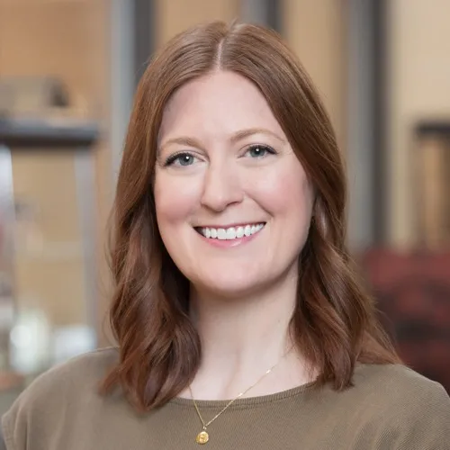Katie Traughber wearing a necklace and smiling.