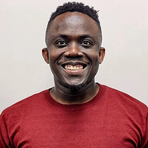 James Baffoe smiling and wearing a red shirt