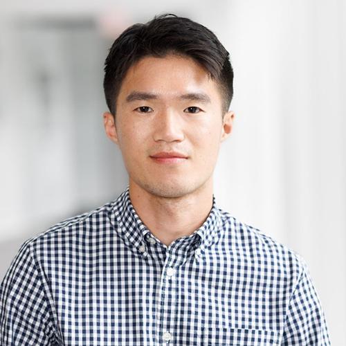 Yi-Shao Liu smiling and wearing a checker-print shirt