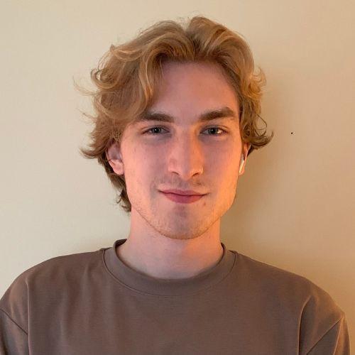 Nick Russell smiling in a brown t-shirt