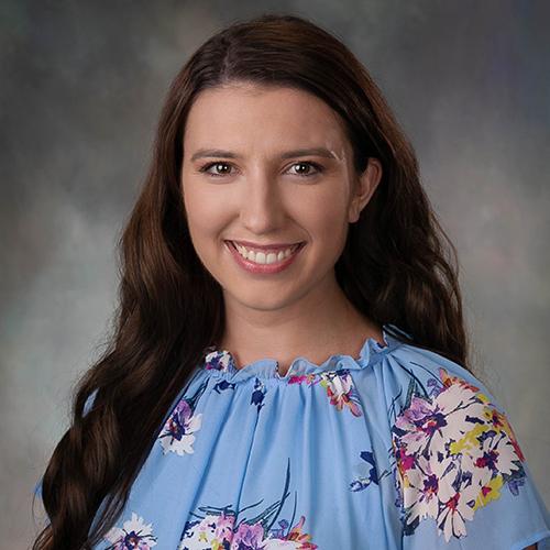 Dr. Olivia Ramey smiling and wearing a floral top