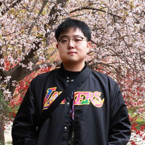 Yubo Wang standing in front of a tree