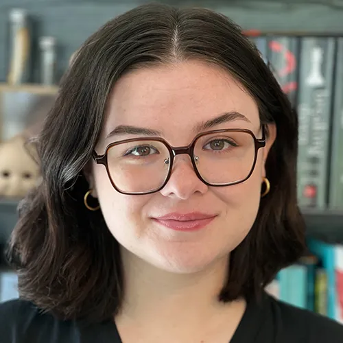 Abigayle Smith smiling in front of a bookshelf