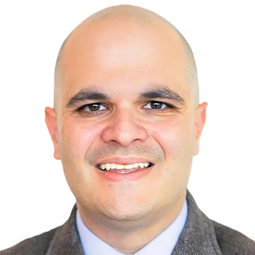 Tyler Varisco smiling and wearing a sport coat