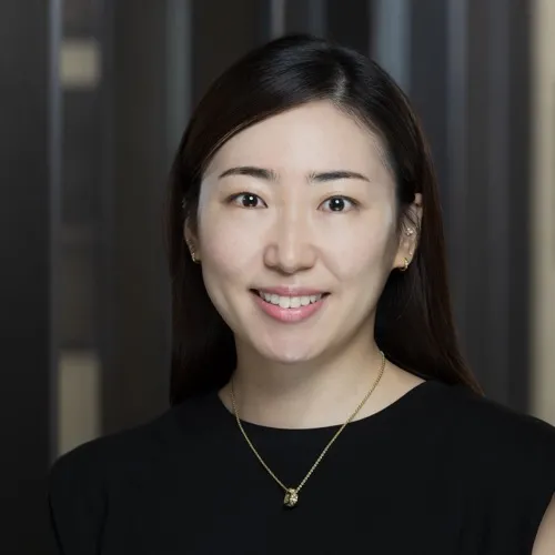 A woman wearing a necklace and smiling.