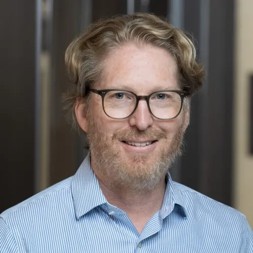 A man wearing glasses and a collared shirt.