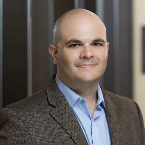 A man wearing a sport coat and collared shirt.