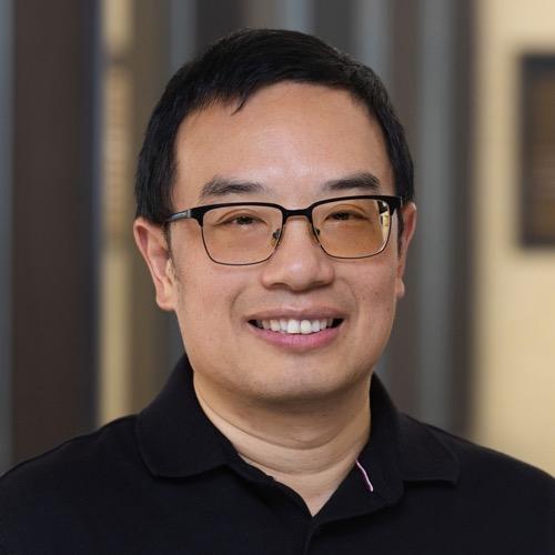 Jie Li wearing glasses and smiling.
