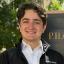 Brayden George smiling in front of the Pharmacy Building sign