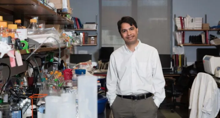 Dr. Som Mukhopadhyay standing in lab surrounded by lab equipment