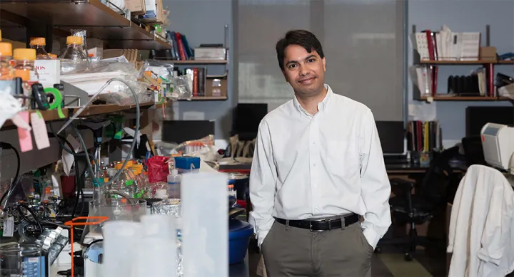 Dr. Mukhopadhyay standing in research laboratory surrounded by scientific equipment