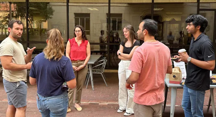 A diverse group of Texas Pharmacy students standing together in the courtyard during a DEAI event.