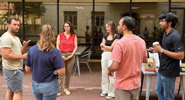 A diverse group of Texas Pharmacy students standing together in the courtyard during a DEAI event.