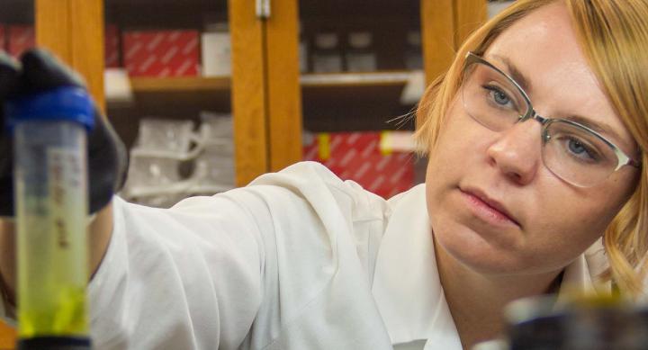 A woman working in the lab in a white coat.