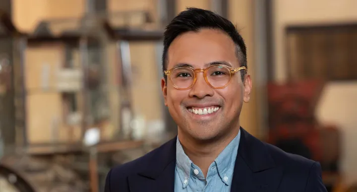 A man wearing glasses and smiling.