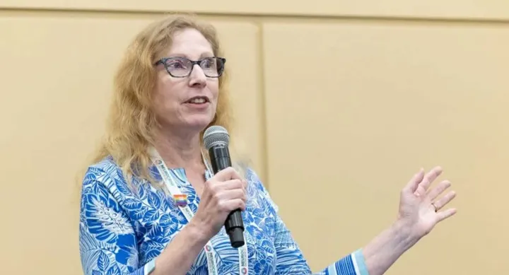 A woman holding a microphone and talking.