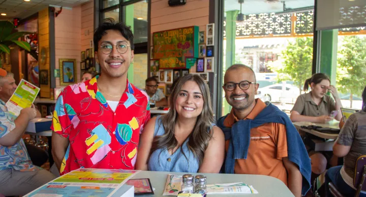 College of Pharmacy staff members smile to camera at a social gathering.