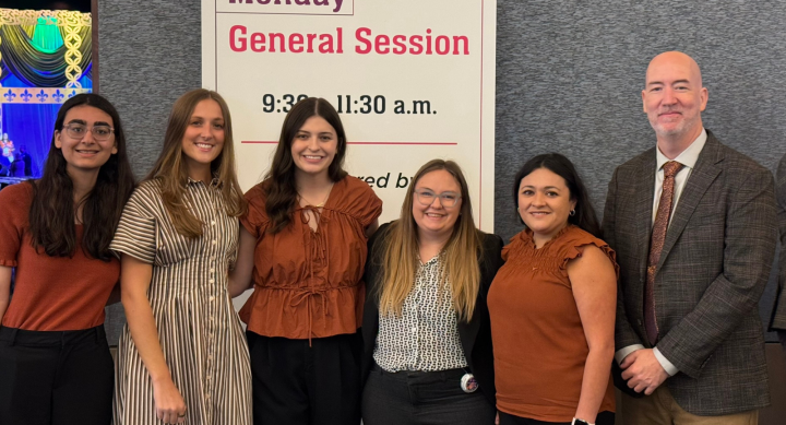 Five female pharmacy students posing with their male faculty advisor at a national competition.
