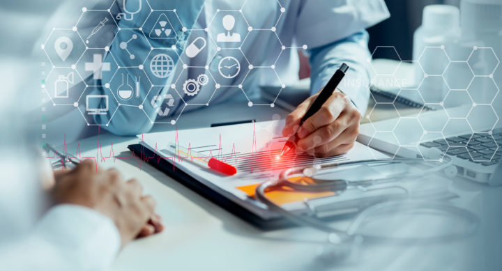 An image of two individuals wearing white coats reviewing digital research and/or data. 