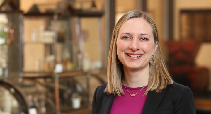 Headshot of Dr. Amanda Stallings. Dr. Stallings has shoulder-length blond hair, blue eyes and is smiling brightly to camera. She is wearing a fuchsia shirt beneath a black blazer.  