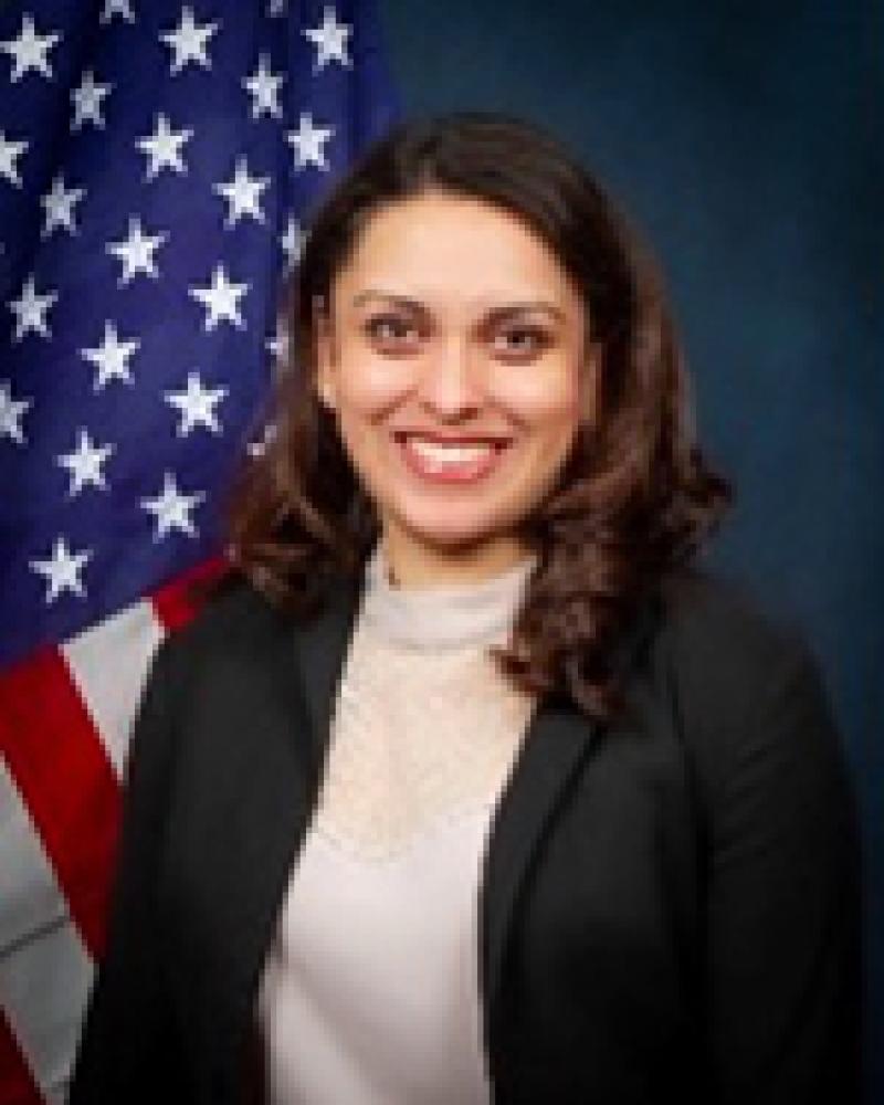 Jacquelyn Brondo smiling in front of an American flag