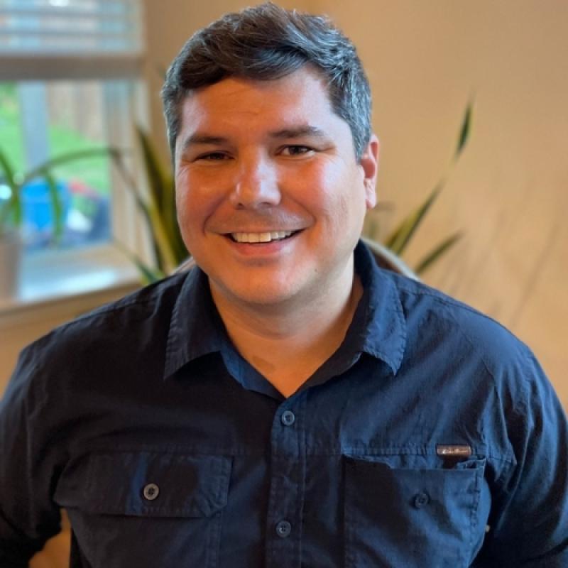 Steven Hutchens smiling and sitting near a window