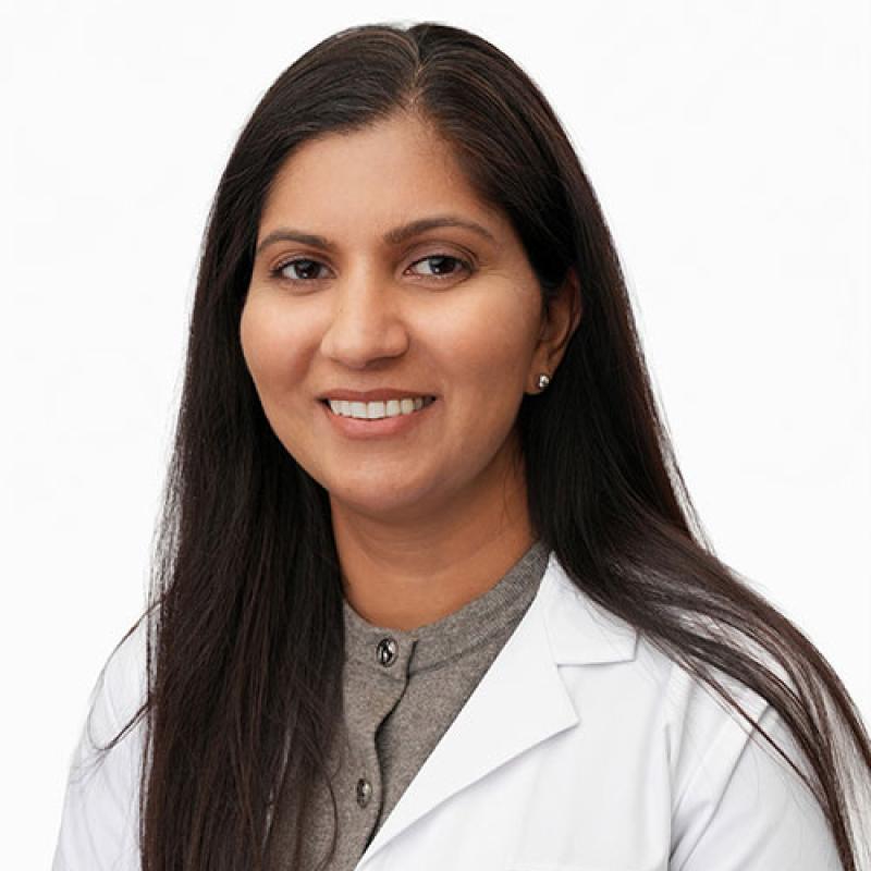 Jessy Thomas smiling and wearing a white coat