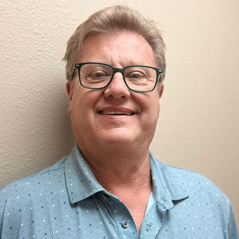 Dr. Jeffrey Warnken smiling in an indoor setting